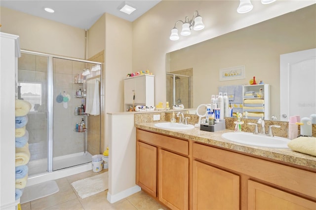 bathroom featuring double vanity, tile patterned floors, a sink, and a shower stall