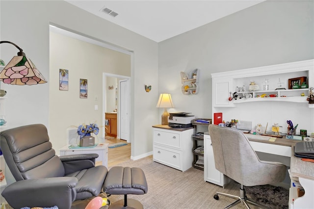 office area with baseboards, visible vents, and light colored carpet