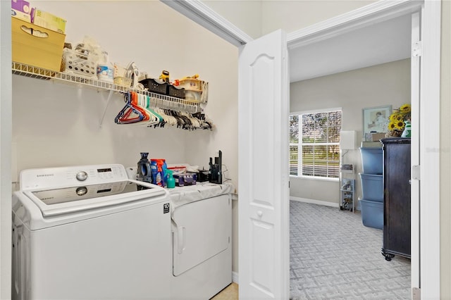 laundry room with laundry area, light colored carpet, independent washer and dryer, and baseboards