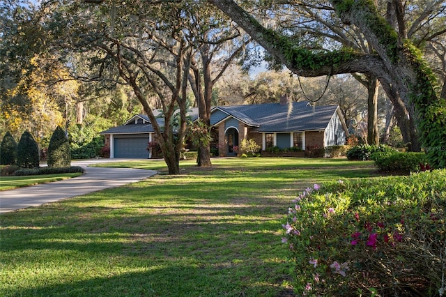 view of front of home with brick siding, a chimney, concrete driveway, a front yard, and a garage