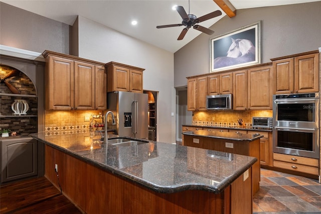 kitchen with brown cabinetry, decorative backsplash, appliances with stainless steel finishes, a peninsula, and a sink