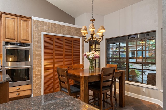 dining area featuring an inviting chandelier, baseboards, and vaulted ceiling