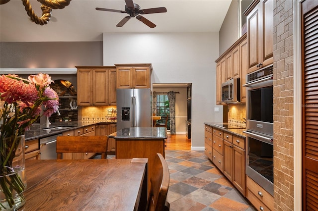 kitchen with stainless steel appliances, brown cabinets, decorative backsplash, and a center island