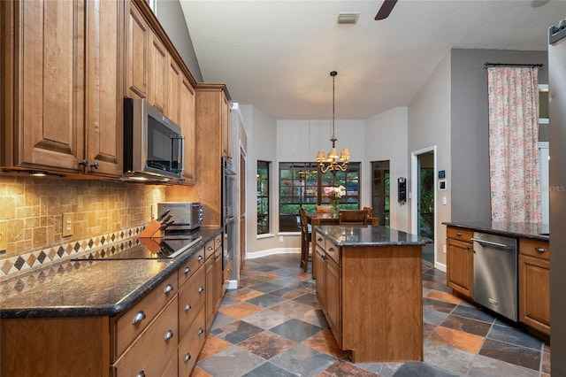 kitchen with appliances with stainless steel finishes, a center island, brown cabinets, and backsplash