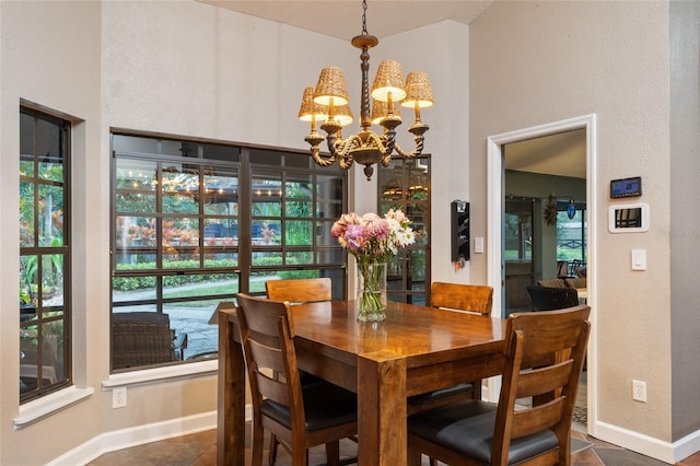 dining room with baseboards and a notable chandelier