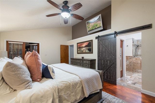 bedroom with a barn door, baseboards, lofted ceiling, ceiling fan, and wood finished floors