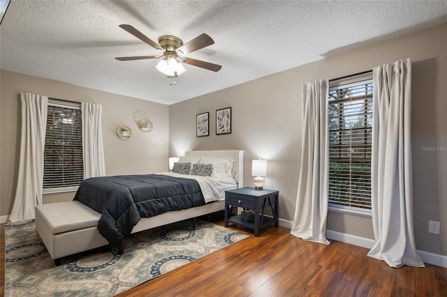 bedroom with a textured ceiling, ceiling fan, wood finished floors, and baseboards