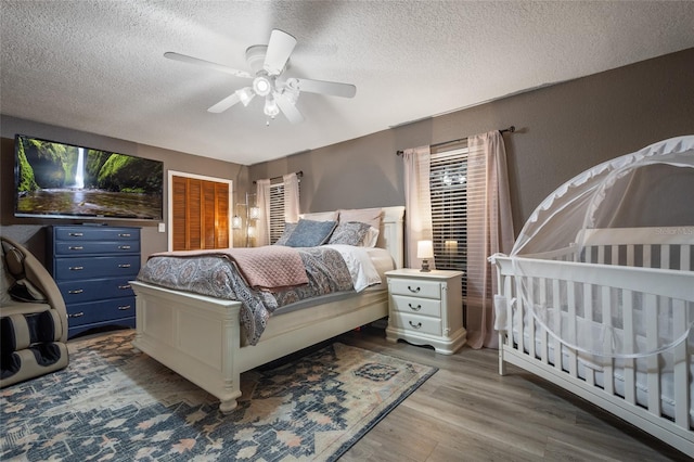 bedroom featuring a textured ceiling, wood finished floors, and a ceiling fan