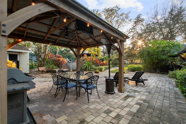 view of patio with a fire pit, a gazebo, and outdoor dining space