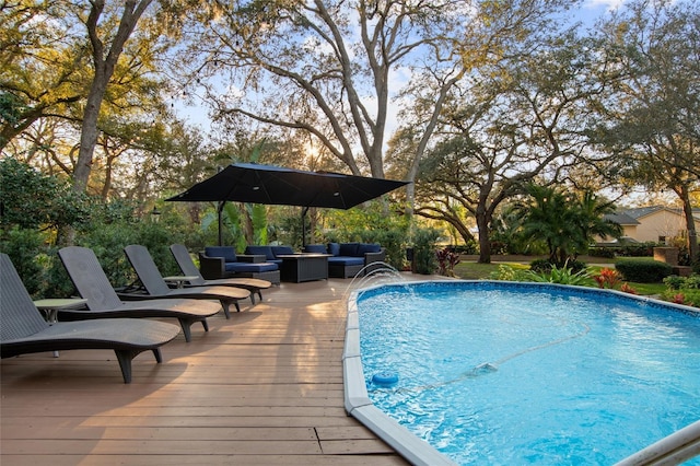 pool featuring outdoor lounge area and a wooden deck