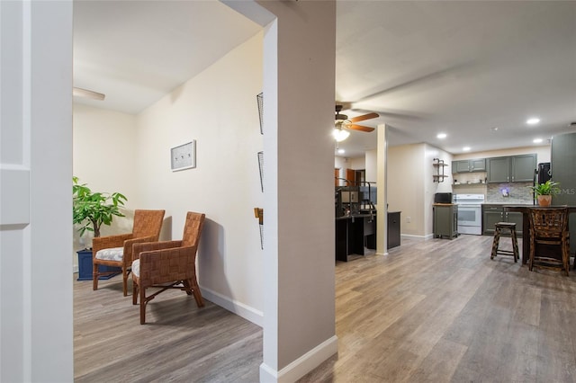 interior space with light wood finished floors, ceiling fan, baseboards, and recessed lighting