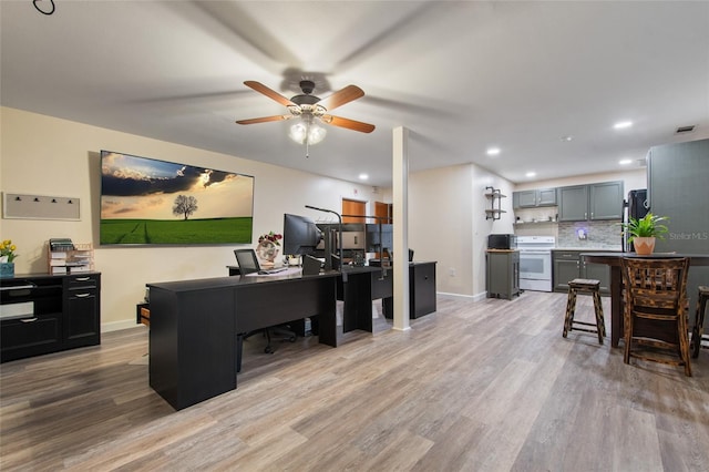 office featuring recessed lighting, a ceiling fan, baseboards, visible vents, and light wood-style floors