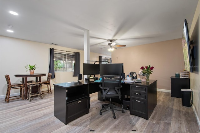 office space featuring light wood-style floors, baseboards, visible vents, and ceiling fan