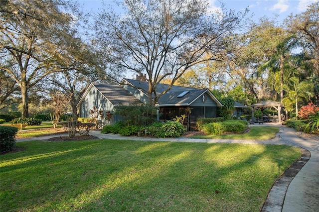 view of front of home with a front lawn and a gazebo