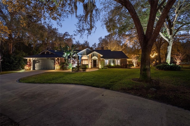 ranch-style house featuring a garage, a front lawn, and concrete driveway