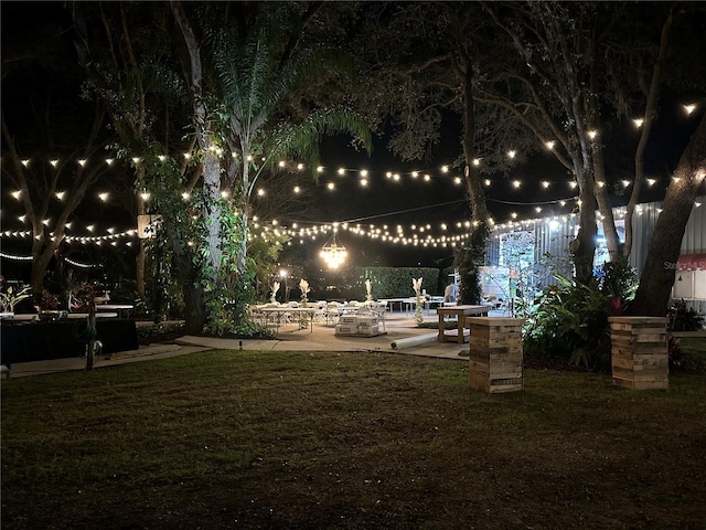 yard at night featuring a patio