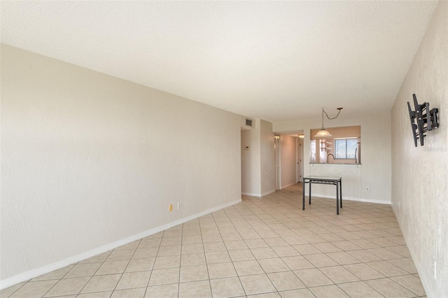 empty room with a textured ceiling, visible vents, and baseboards