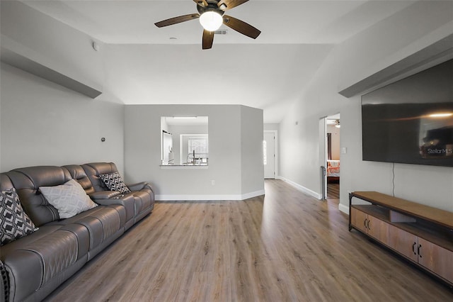 living room with vaulted ceiling, ceiling fan, wood finished floors, and baseboards