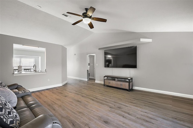 living room featuring visible vents, baseboards, lofted ceiling, ceiling fan, and wood finished floors