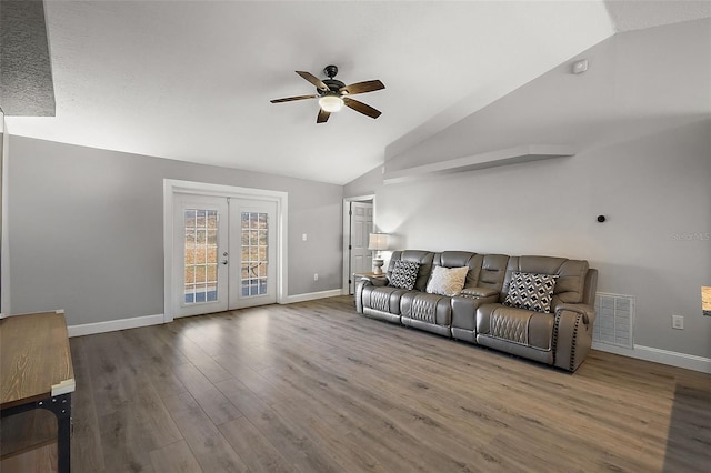 living room with visible vents, vaulted ceiling, wood finished floors, and french doors