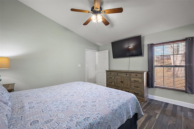 bedroom featuring lofted ceiling, dark wood-style flooring, a ceiling fan, and baseboards