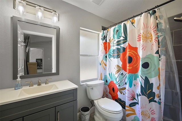 bathroom featuring a textured ceiling, curtained shower, toilet, vanity, and visible vents