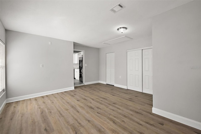 spare room with visible vents, baseboards, and wood finished floors