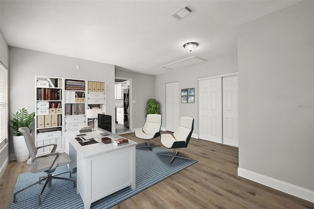 office with baseboards, visible vents, and wood finished floors