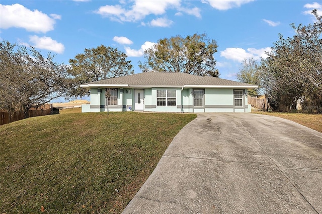 single story home with driveway, stucco siding, fence, and a front yard