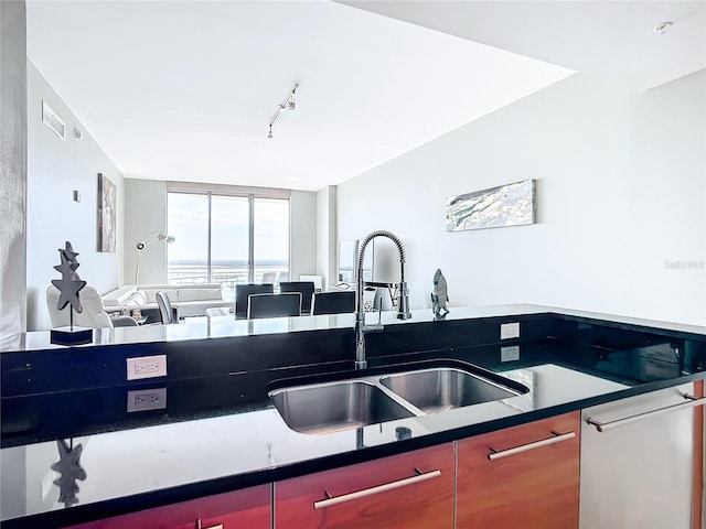 kitchen with white dishwasher, a sink, visible vents, open floor plan, and rail lighting