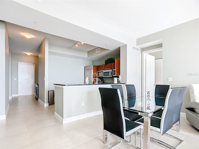 dining room featuring light tile patterned flooring, a raised ceiling, visible vents, and baseboards