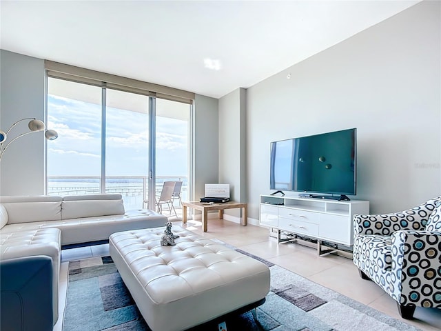 living room with light tile patterned floors, baseboards, and a wall of windows