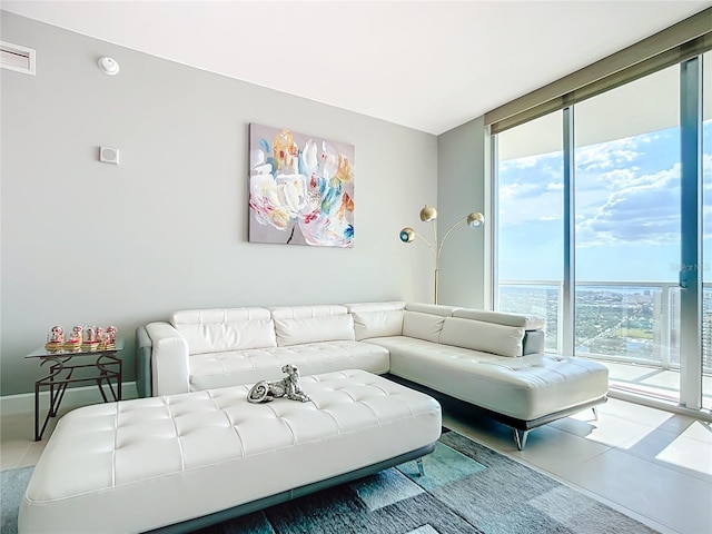 tiled living area featuring expansive windows and visible vents