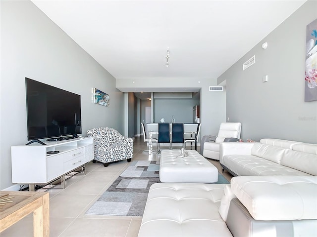 living area featuring light tile patterned flooring and visible vents