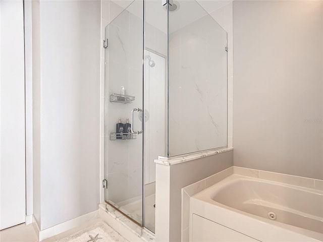 bathroom with a shower stall and a bath