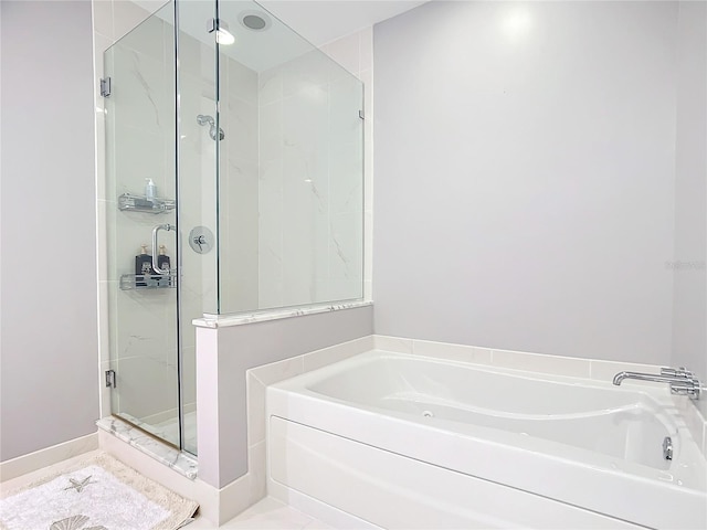 bathroom featuring a garden tub and a shower stall