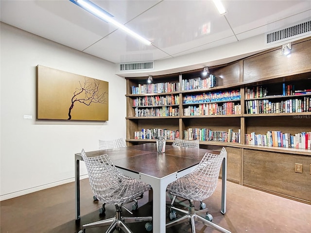 office space featuring built in shelves, visible vents, and baseboards