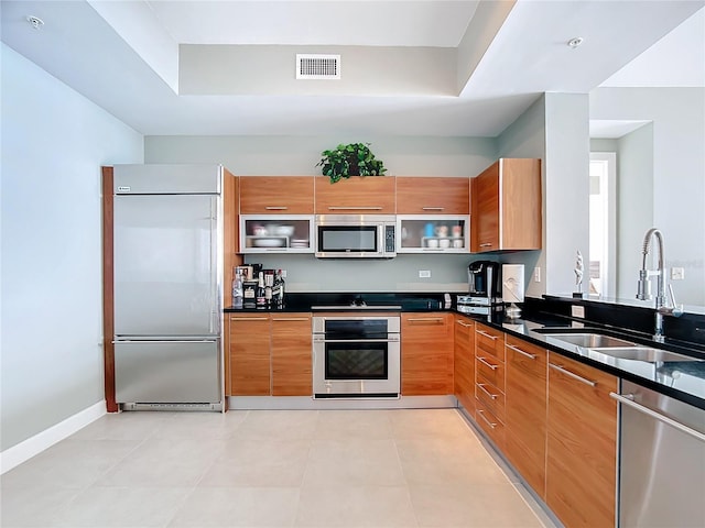 kitchen featuring stainless steel appliances, modern cabinets, a sink, and visible vents