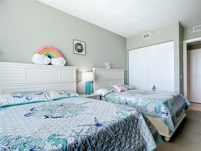 bedroom with a closet, visible vents, and wood finished floors