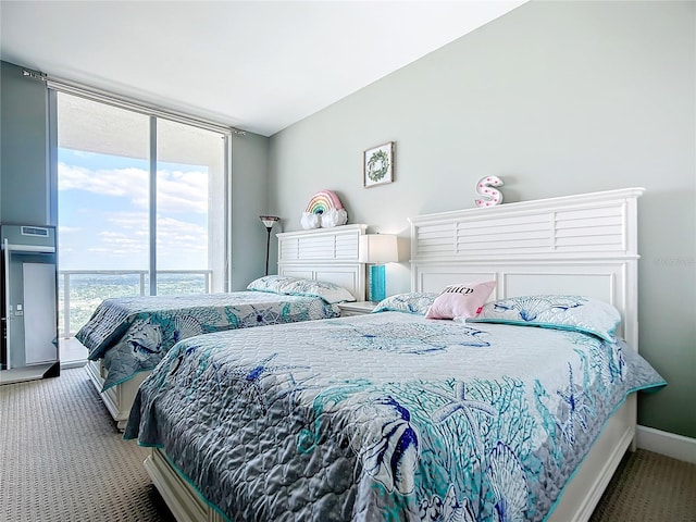 carpeted bedroom featuring baseboards and a wall of windows