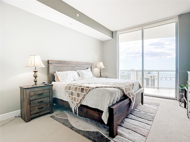 bedroom with expansive windows, baseboards, light colored carpet, and access to exterior