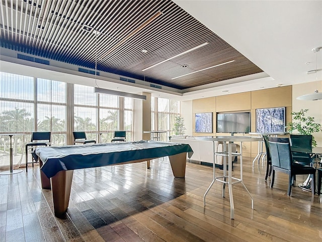 recreation room with pool table, wood-type flooring, and a raised ceiling