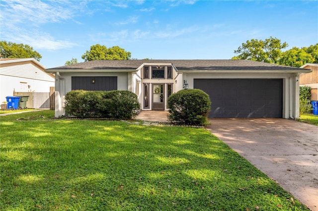 mid-century home with a garage, concrete driveway, fence, a front yard, and stucco siding