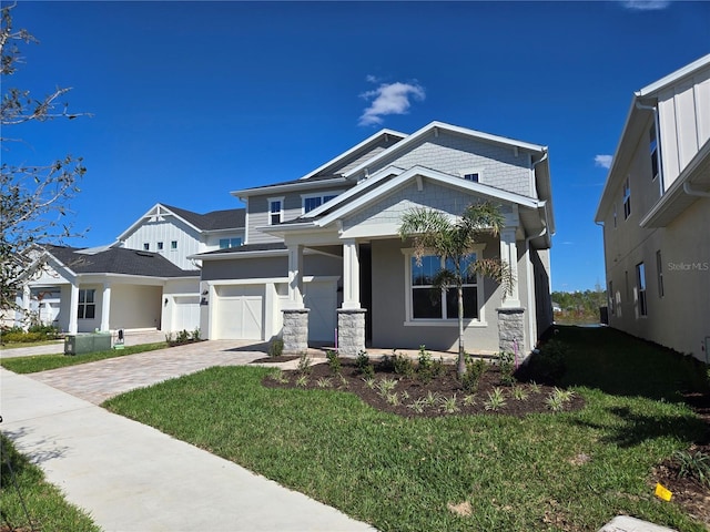 view of front of property with a garage, decorative driveway, and a front yard