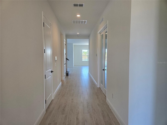 hall with recessed lighting, visible vents, light wood-style flooring, and baseboards