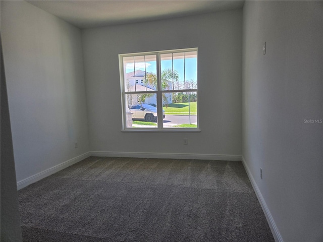 carpeted empty room featuring baseboards