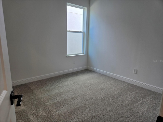 carpeted spare room with baseboards