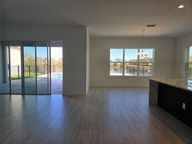 unfurnished living room featuring wood finished floors and a wealth of natural light