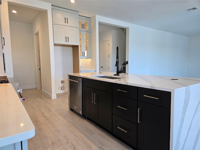 kitchen with visible vents, dishwasher, a kitchen island with sink, dark cabinetry, and white cabinetry