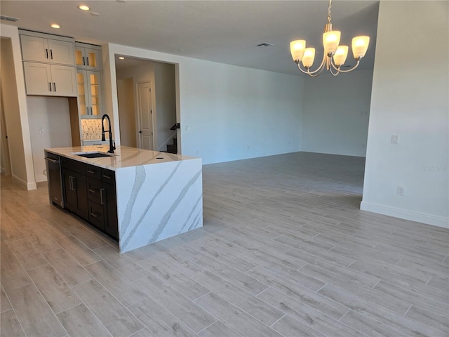 kitchen with glass insert cabinets, wood finish floors, a sink, and dishwasher